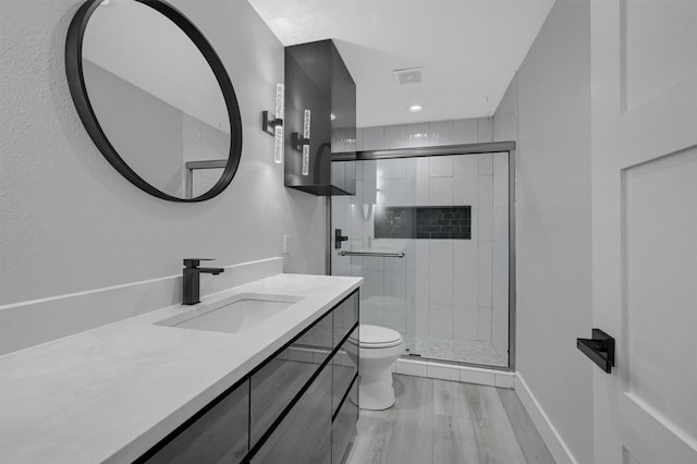 full bathroom with a shower stall, wood finished floors, visible vents, toilet, and vanity