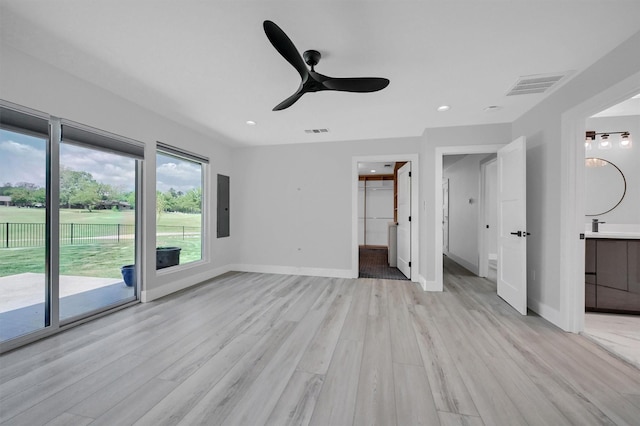 unfurnished bedroom with light wood-style floors, electric panel, baseboards, access to outside, and visible vents