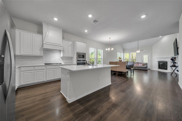 kitchen with stainless steel appliances, visible vents, a glass covered fireplace, open floor plan, and custom range hood