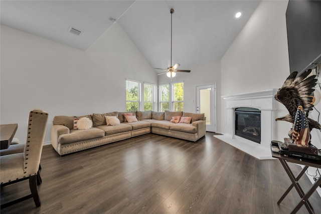 living room featuring high vaulted ceiling, a ceiling fan, wood finished floors, a glass covered fireplace, and visible vents
