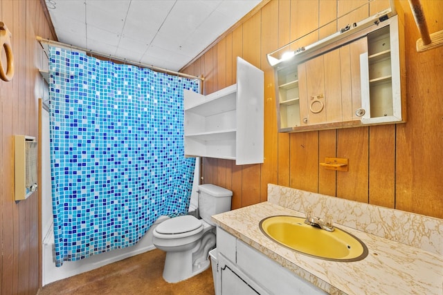 bathroom featuring wood walls, toilet, vanity, and curtained shower