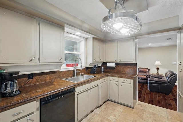 kitchen featuring dark countertops, a sink, black dishwasher, recessed lighting, and visible vents