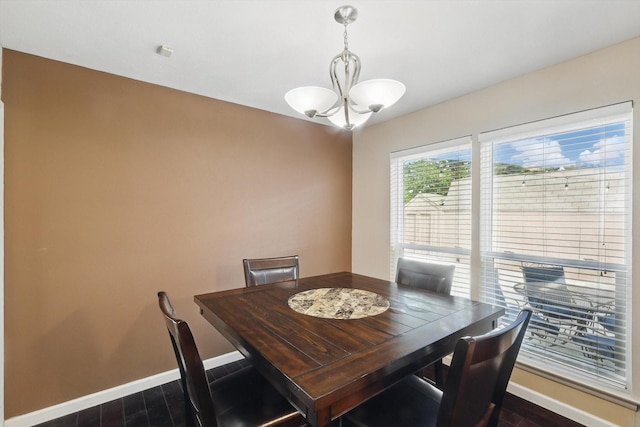 dining area with baseboards, an inviting chandelier, and dark wood-type flooring