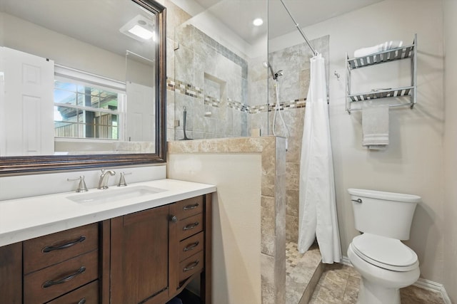 full bathroom with vanity, toilet, and tiled shower