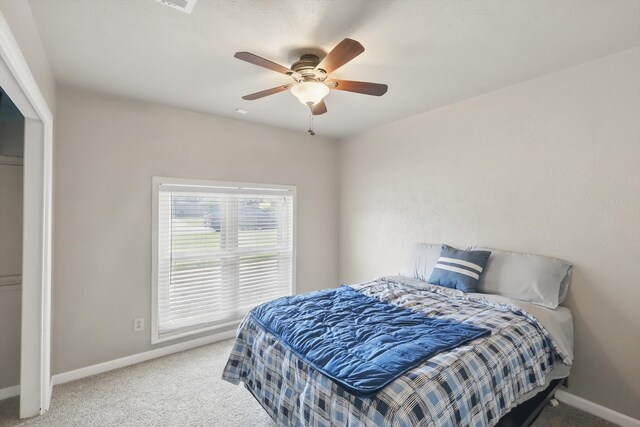 carpeted bedroom with baseboards and ceiling fan