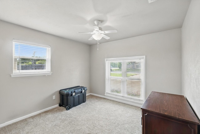 interior space featuring baseboards, a ceiling fan, and carpet