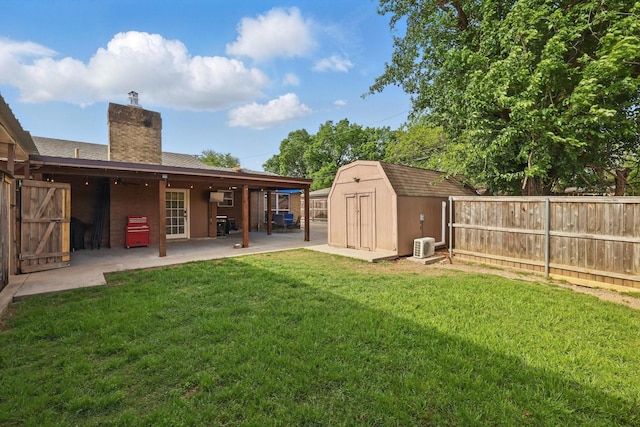 view of yard featuring a storage shed, an outdoor structure, a fenced backyard, and a patio area