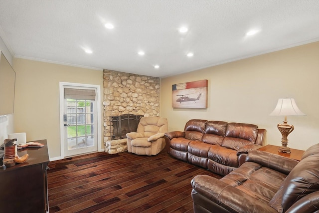 living room featuring crown molding, recessed lighting, a stone fireplace, and dark wood-style floors