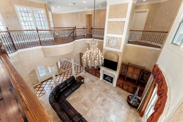 stairs with recessed lighting, ornamental molding, an inviting chandelier, and plenty of natural light