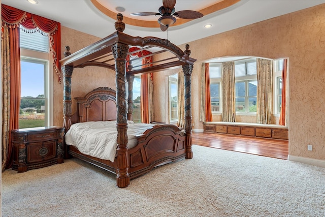 bedroom featuring carpet, wood finished floors, baseboards, and multiple windows