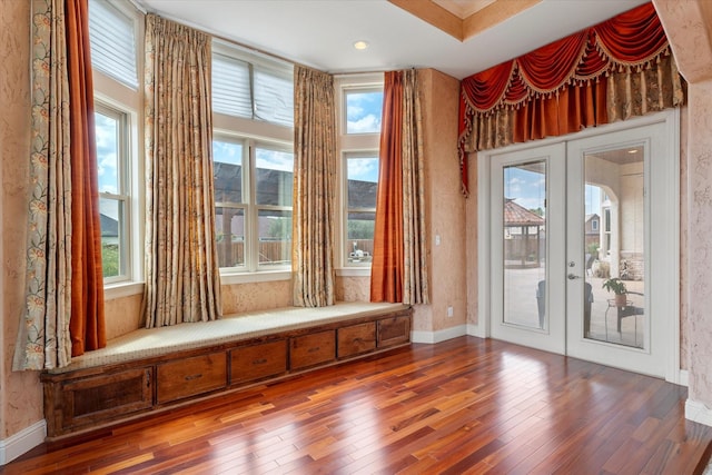 interior space with baseboards, french doors, and hardwood / wood-style floors