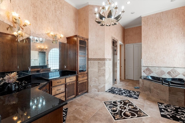 bathroom with vanity, tile walls, crown molding, a garden tub, and a notable chandelier