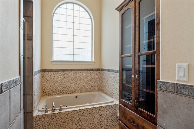 full bathroom featuring wainscoting, a garden tub, tile walls, and plenty of natural light