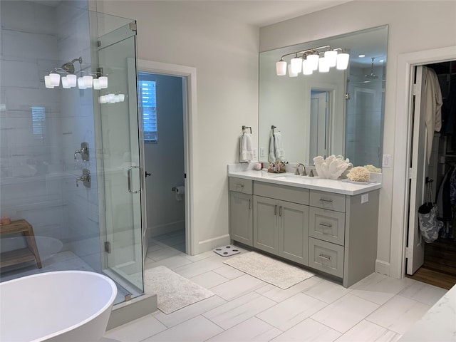 bathroom featuring a shower stall, vanity, a freestanding bath, and baseboards