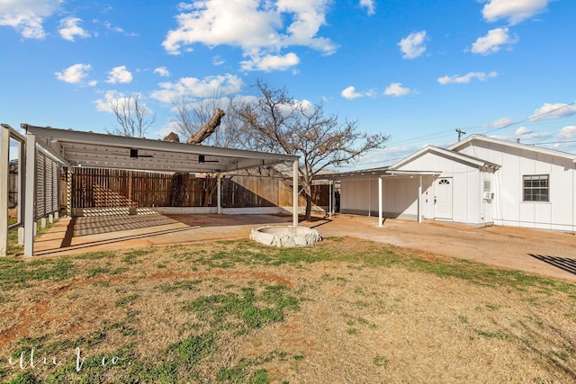 back of property featuring fence, a yard, and board and batten siding