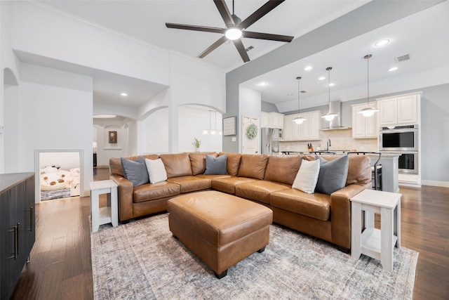 7512 Sabine Dr, Mckinney, TX 75071 - living room with arched walkways, a ceiling fan, wood finished floors, ornamental molding, and recessed lighting