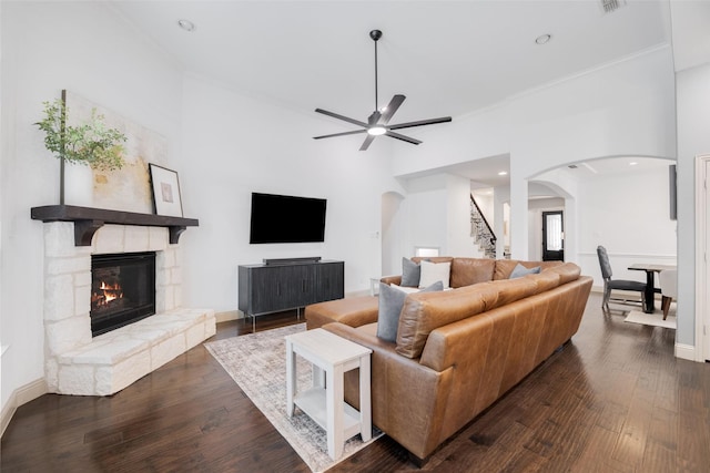 7512 Sabine Dr, Mckinney, TX 75071 - living room featuring arched walkways, stairs, ceiling fan, dark wood finished floors, and a high ceiling
