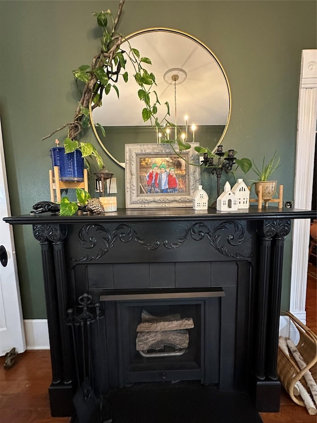 501 N Austin St, Comanche, TX 76442 - detailed view of a fireplace, wood finished floors, baseboards, and a chandelier