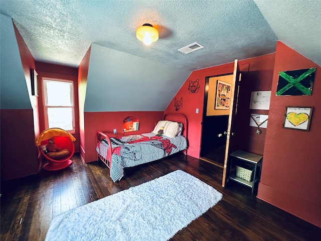 501 N Austin St, Comanche, TX 76442 - bedroom featuring a textured ceiling, wood finished floors, vaulted ceiling, and baseboards