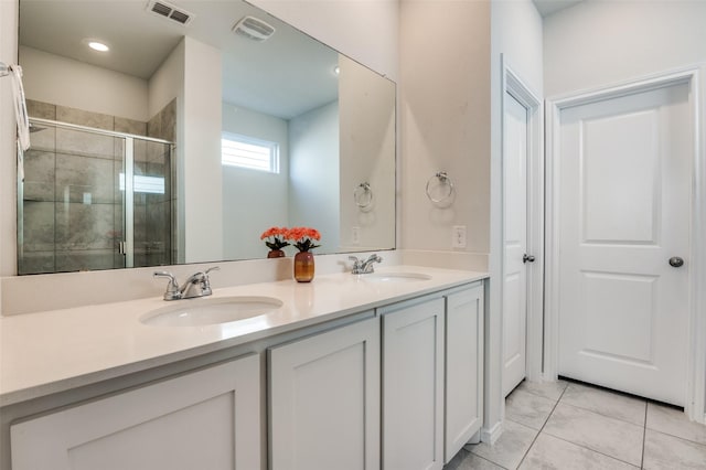 bathroom featuring visible vents, a sink, a shower stall, and double vanity