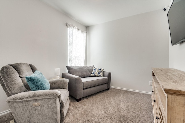 living area featuring baseboards and light colored carpet