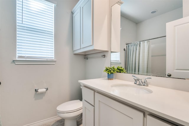 full bath with toilet, vanity, curtained shower, and baseboards