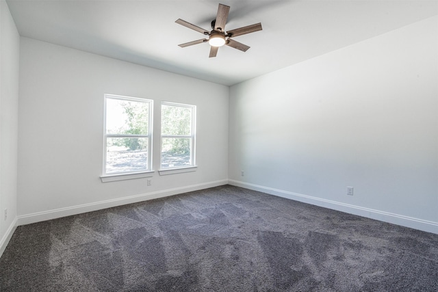 unfurnished room featuring a ceiling fan, baseboards, and dark colored carpet