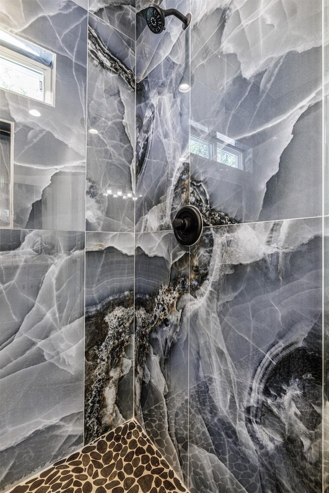full bath featuring a marble finish shower and a wealth of natural light