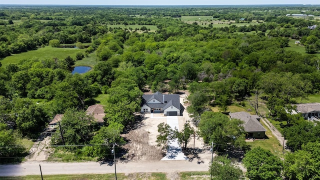birds eye view of property featuring a water view and a forest view
