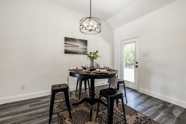 dining space featuring baseboards, dark wood finished floors, a notable chandelier, and vaulted ceiling