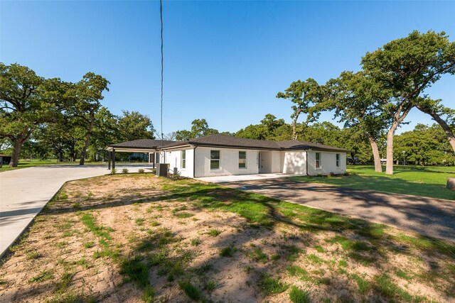 view of front of property featuring central AC, driveway, and a front yard