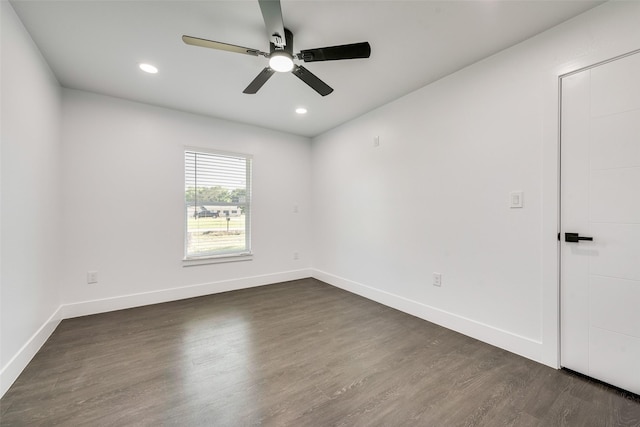 empty room featuring baseboards, a ceiling fan, and dark wood-style floors