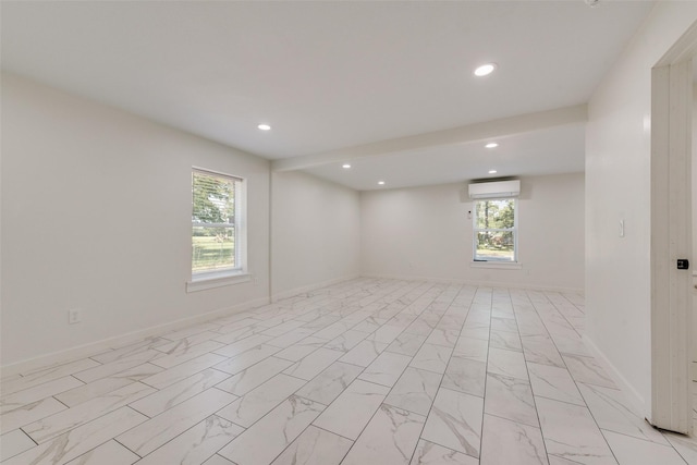 spare room with recessed lighting, a wall unit AC, marble finish floor, and baseboards