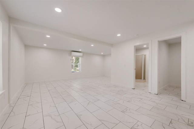 basement with recessed lighting, a wall mounted air conditioner, and marble finish floor