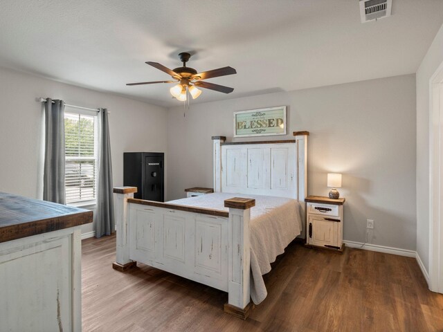 bedroom featuring ceiling fan, baseboards, visible vents, and wood finished floors