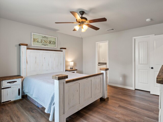 bedroom featuring visible vents, a ceiling fan, dark wood finished floors, and baseboards