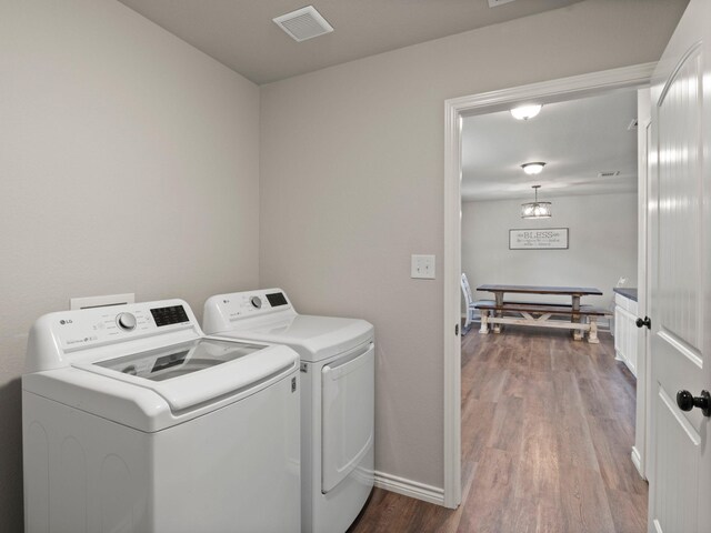 washroom with independent washer and dryer, laundry area, baseboards, wood finished floors, and visible vents