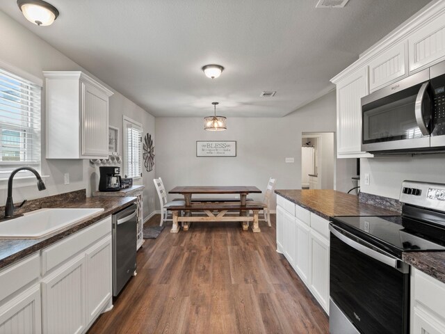 dining room with plenty of natural light, a notable chandelier, dark wood finished floors, and visible vents