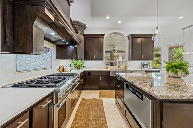 kitchen with recessed lighting, dark brown cabinets, tasteful backsplash, and range with two ovens