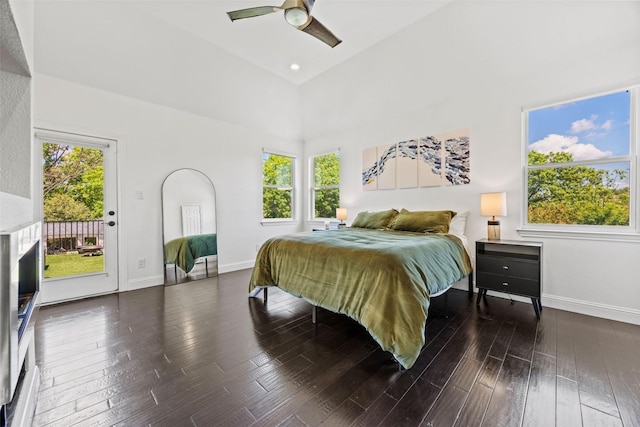 bedroom featuring wood-type flooring, access to exterior, baseboards, and multiple windows