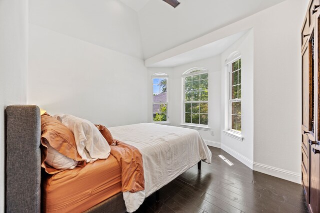 bedroom with vaulted ceiling, baseboards, and dark wood-style flooring