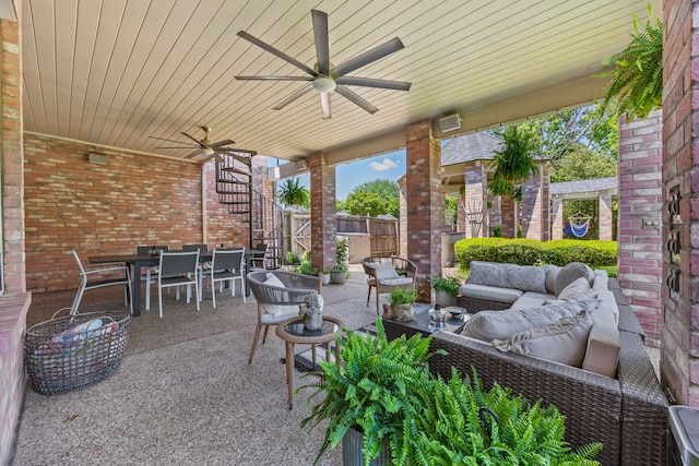 view of patio / terrace featuring a ceiling fan, outdoor dining space, fence, an outdoor hangout area, and stairs