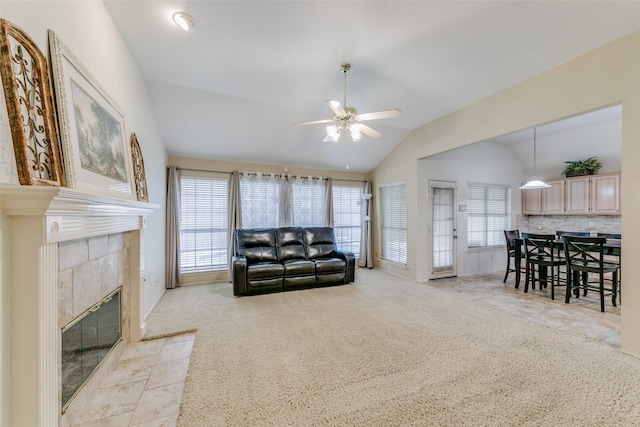 living area featuring lofted ceiling, plenty of natural light, light colored carpet, and ceiling fan