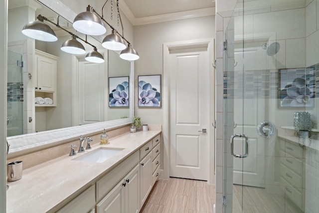 full bathroom featuring crown molding, a stall shower, and vanity