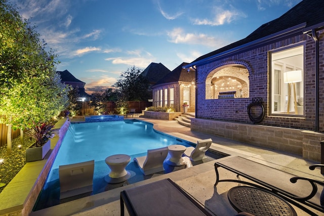 view of pool with a patio area, a fenced backyard, and a pool with connected hot tub
