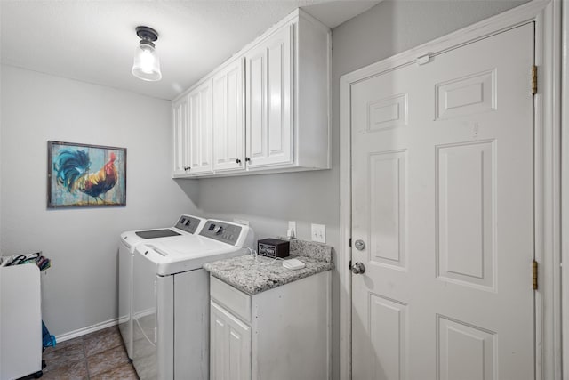 washroom featuring washing machine and dryer, cabinet space, and baseboards