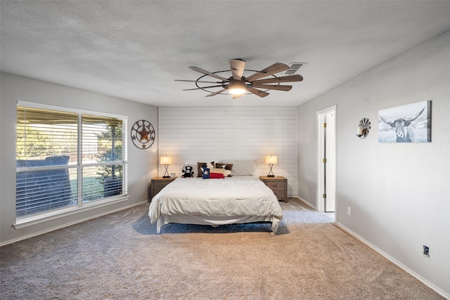 bedroom with visible vents, baseboards, a textured ceiling, carpet flooring, and ceiling fan