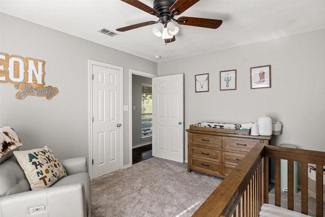 carpeted bedroom featuring a ceiling fan and visible vents