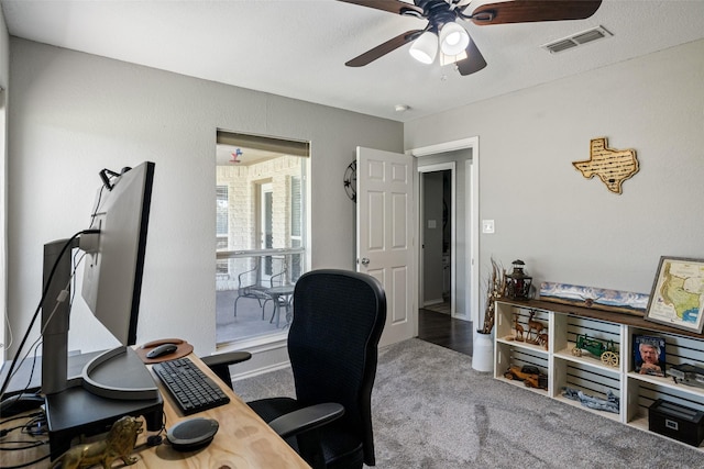 carpeted office space with a ceiling fan and visible vents