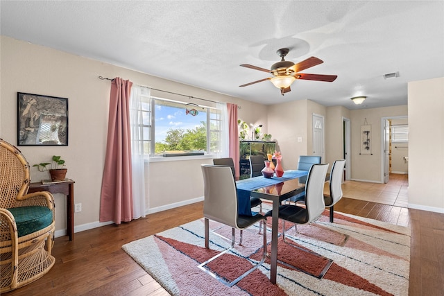dining area with wood-type flooring, visible vents, and plenty of natural light